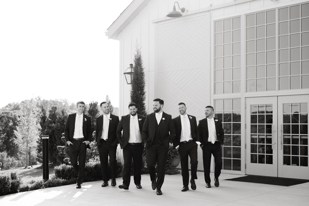 The wedding party posing with Alyssa and Matthew in navy and champagne attire at Westwind Hills.