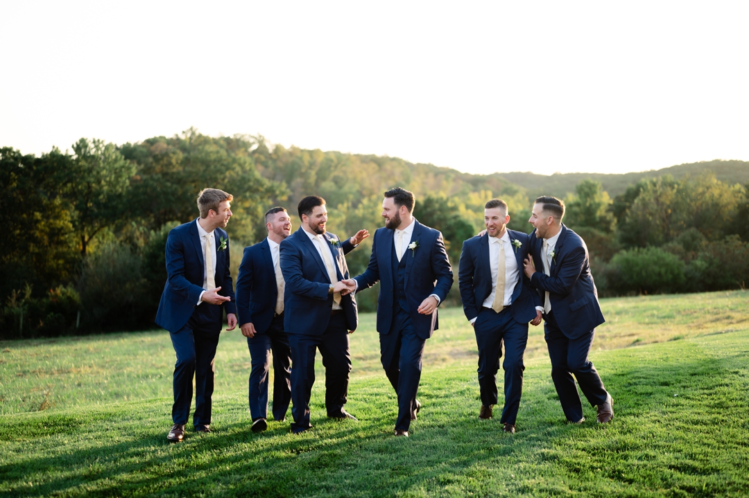 The wedding party posing with Alyssa and Matthew in navy and champagne attire at Westwind Hills.