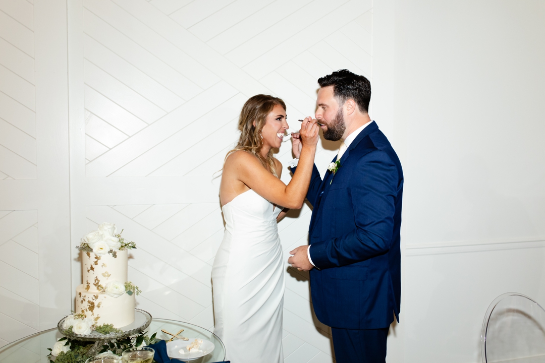 Alyssa and Matthew cutting their elegant white wedding cake at their Westwind Hills reception.