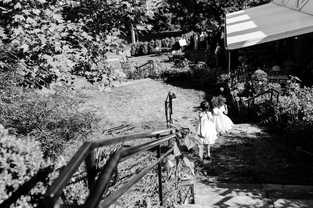 Guests enjoying cocktail hour at Sunflower Hill Farm, mingling under the covered patio with scenic views in the background.