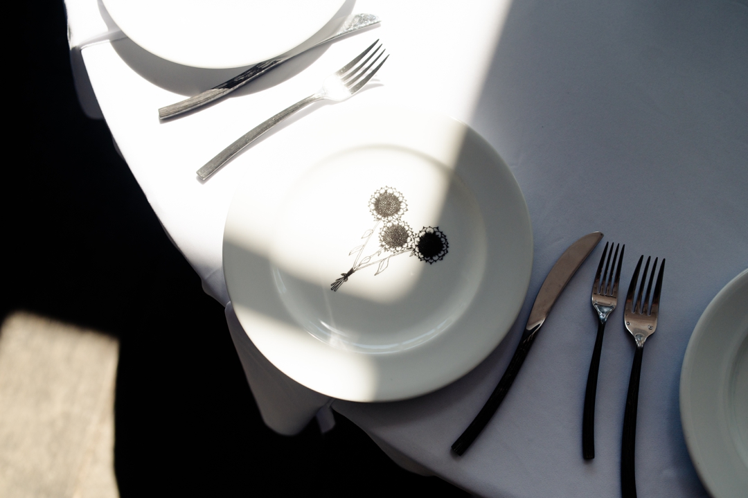 Reception tables set under the covered patio at Sunflower Hill Farm, with open doors connecting to the indoor space for a seamless celebration.