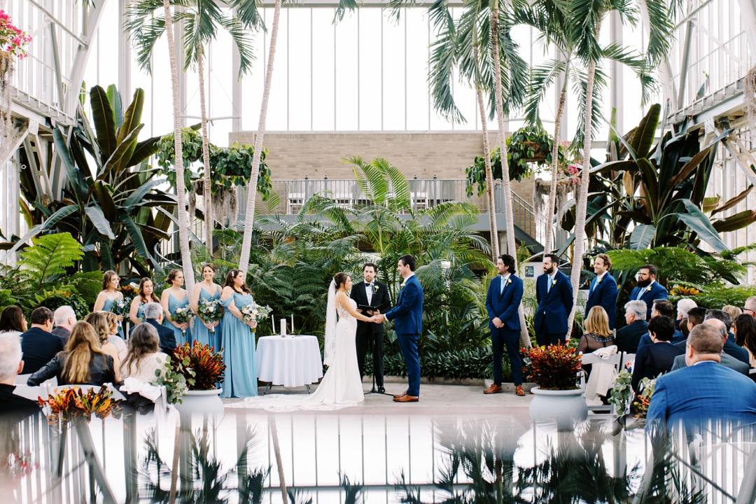 Elegant ceremony setup inside The Jewel Box with botanical decor and glass walls.