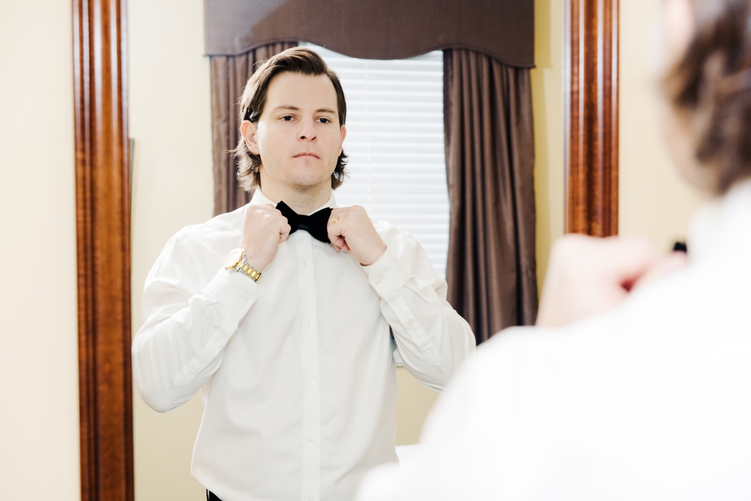 Jeff adjusting his tie in preparation for his wedding at the Missouri Athletic Club, captured by Fanara Photography.