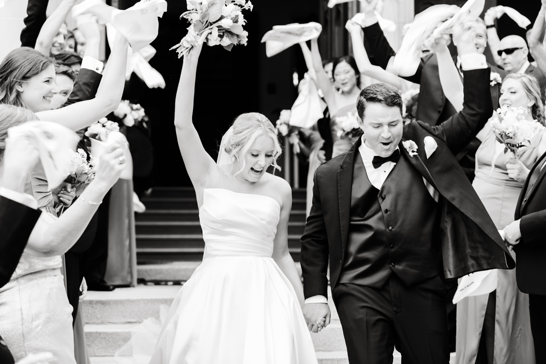 Guests waving St. Louis Blues rally towels during Amanda and Mike’s wedding send-off.