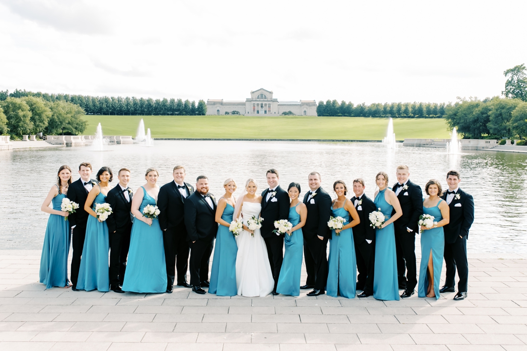 Amanda and Mike posing with their wedding party in Forest Park on a sunny afternoon.