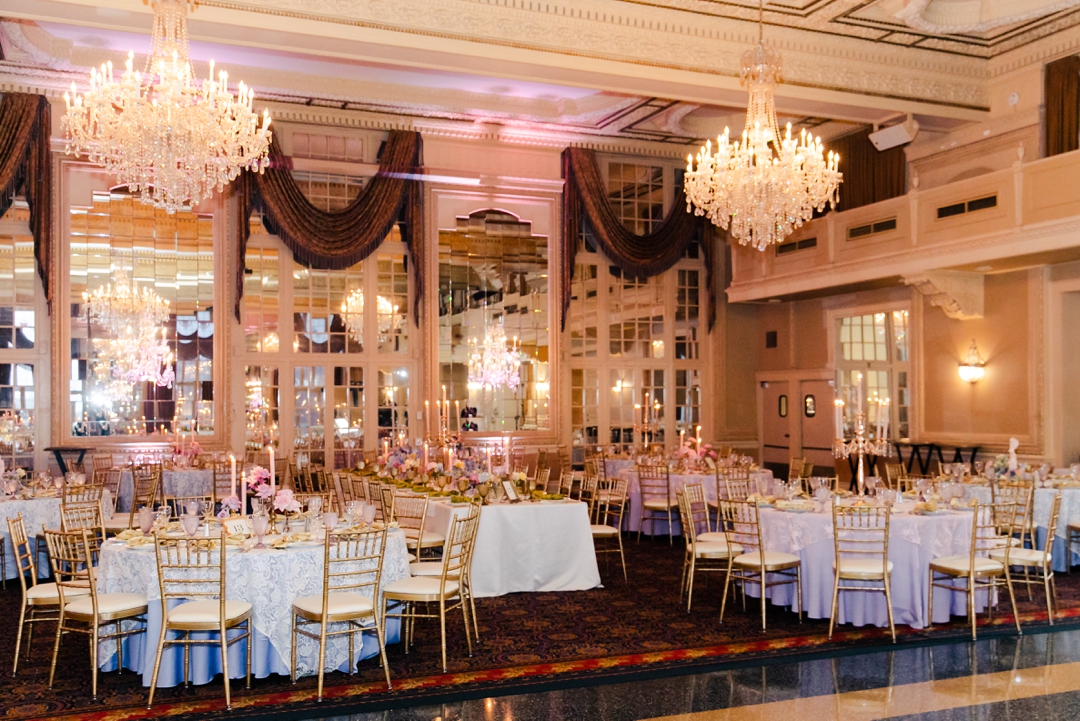 Wide shot of the reception space showcasing colorful florals, candles, and whimsical décor at Deane and Jeff’s wedding.