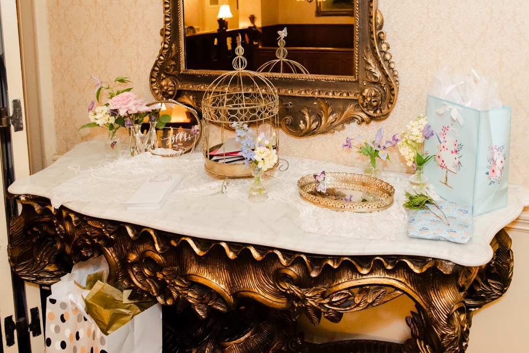 Elegant reception table featuring mismatched vintage plates, butterfly accents, and lush floral centerpieces at the Missouri Athletic Club.