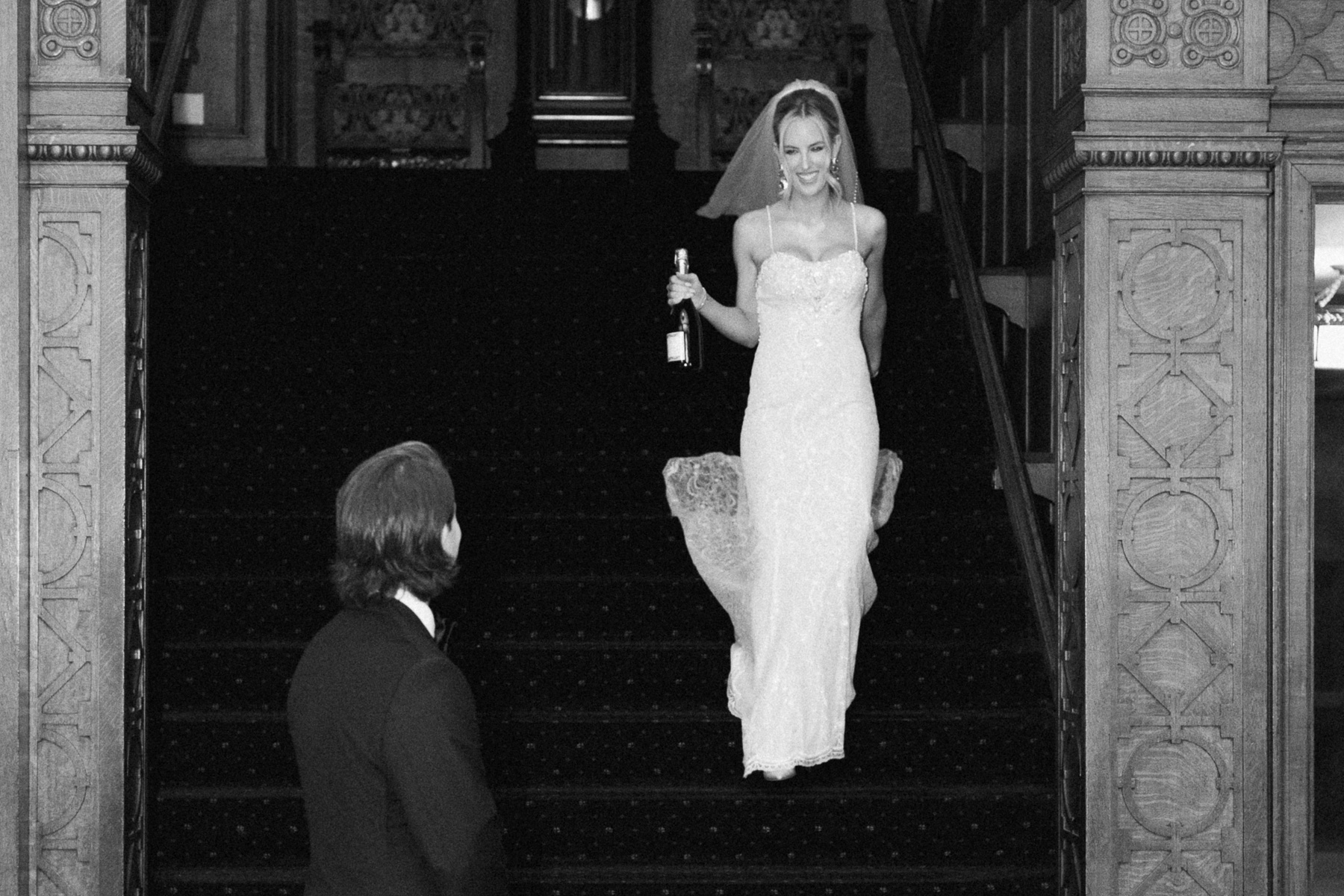Bride holding a champagne bottle during first look photos at the Missouri Athletic Club in St. Louis