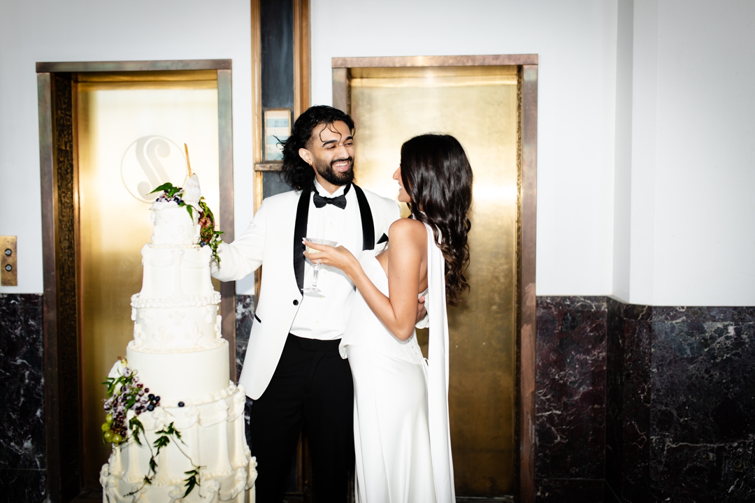 Three-tiered Art Deco-inspired wedding cake by Cake House Design, featuring sleek geometric patterns and floral accents, set against The Noble St. Louis wedding venue.