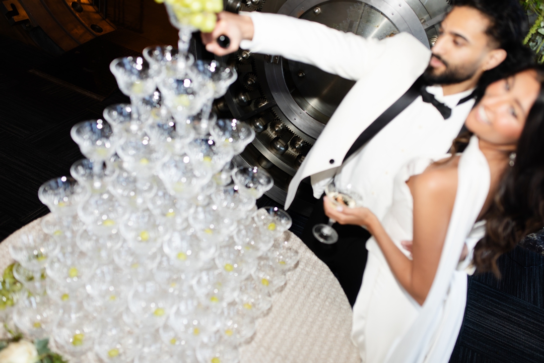 Elegant champagne tower set up by The Aries Company, creating a glamorous moment at The Noble St. Louis wedding venue.