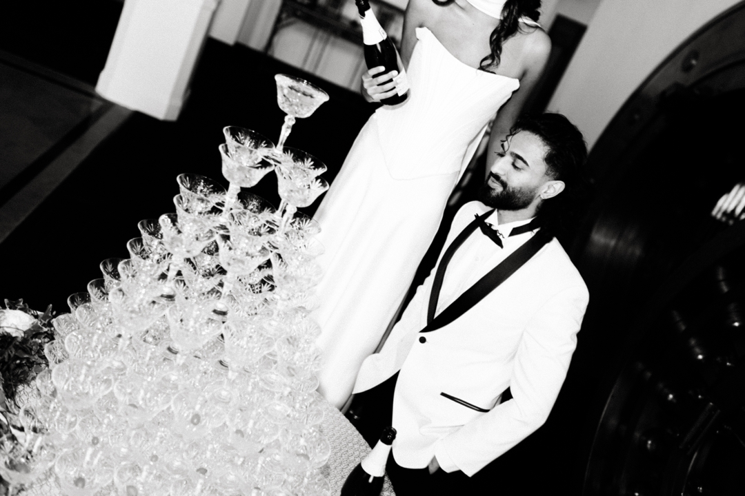 Elegant champagne tower set up by The Aries Company, creating a glamorous moment at The Noble St. Louis wedding venue.