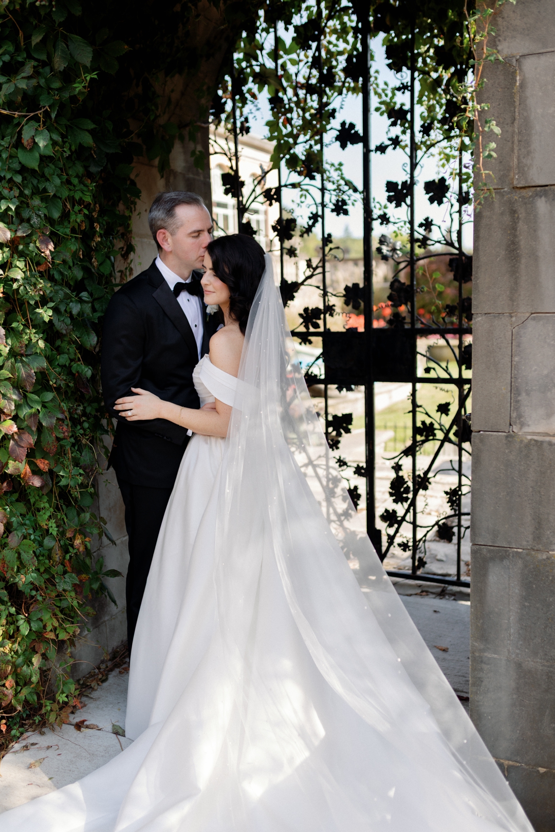 Couple standing at the gates of Loyola at Cuneo Mansion & Gardens in Chicago, captured in a refined editorial style