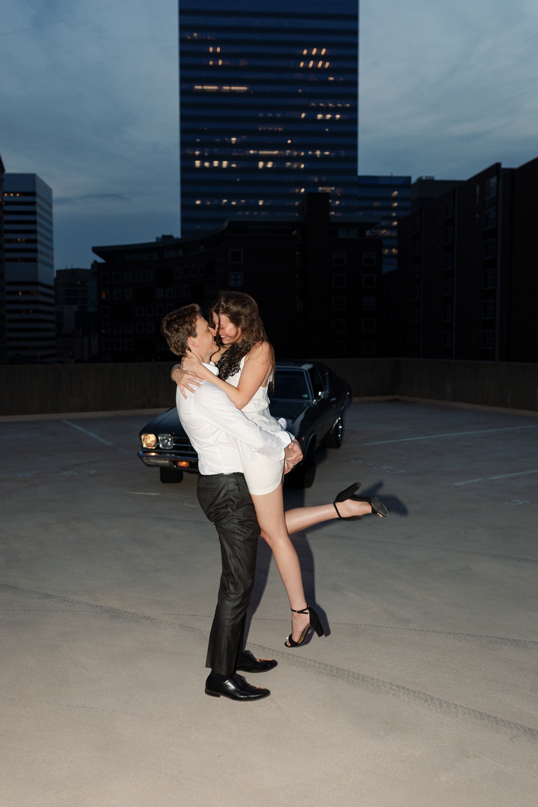 engagment highlights of couple in almost kissing in front of car in downtown clayton loose editorial style