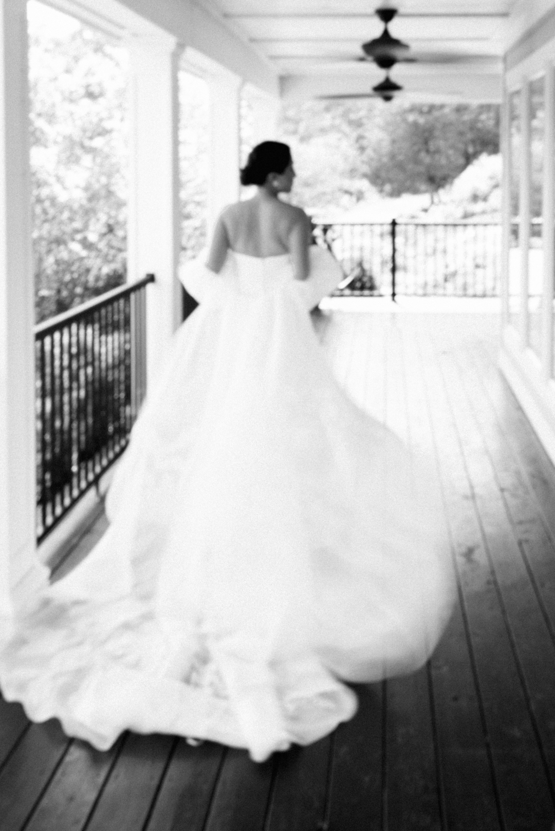Elegant bride twirling on a porch in St. Louis, captured in black and white