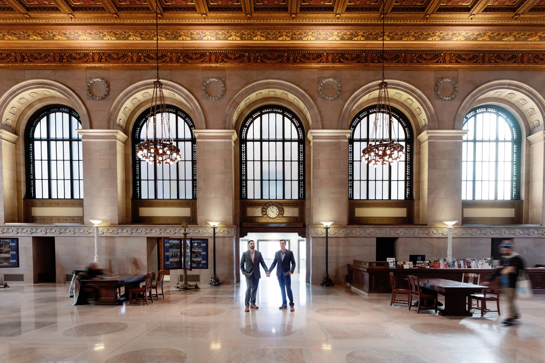 LGBTQ+ couple inside St. Louis Central Library in a loose editorial style.