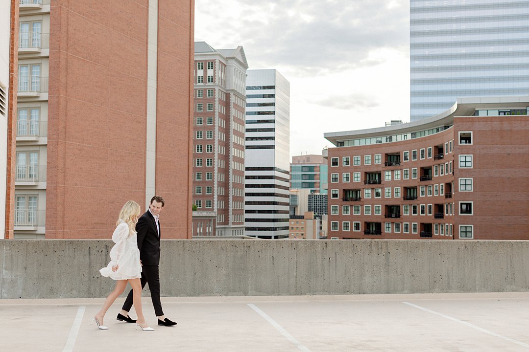 Couple crossing the street during downtown Clayton engagement photos