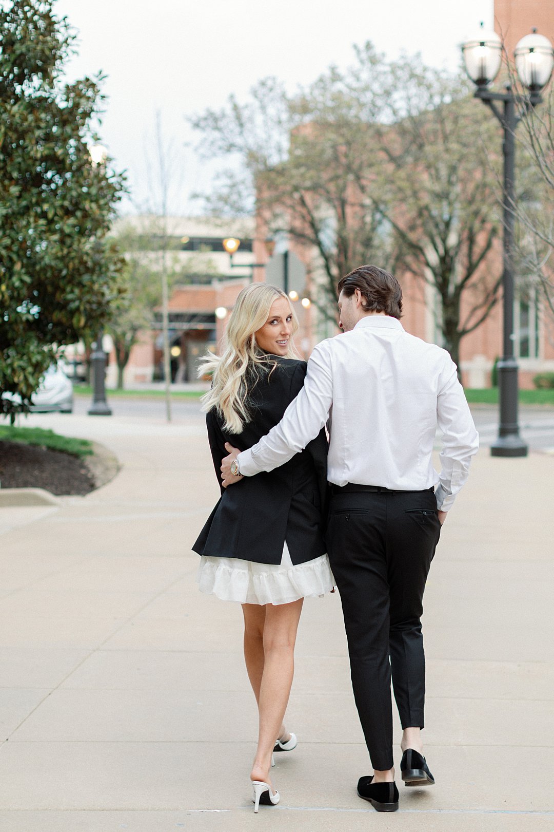 Couple walking hand in hand in downtown Clayton engagement photos
