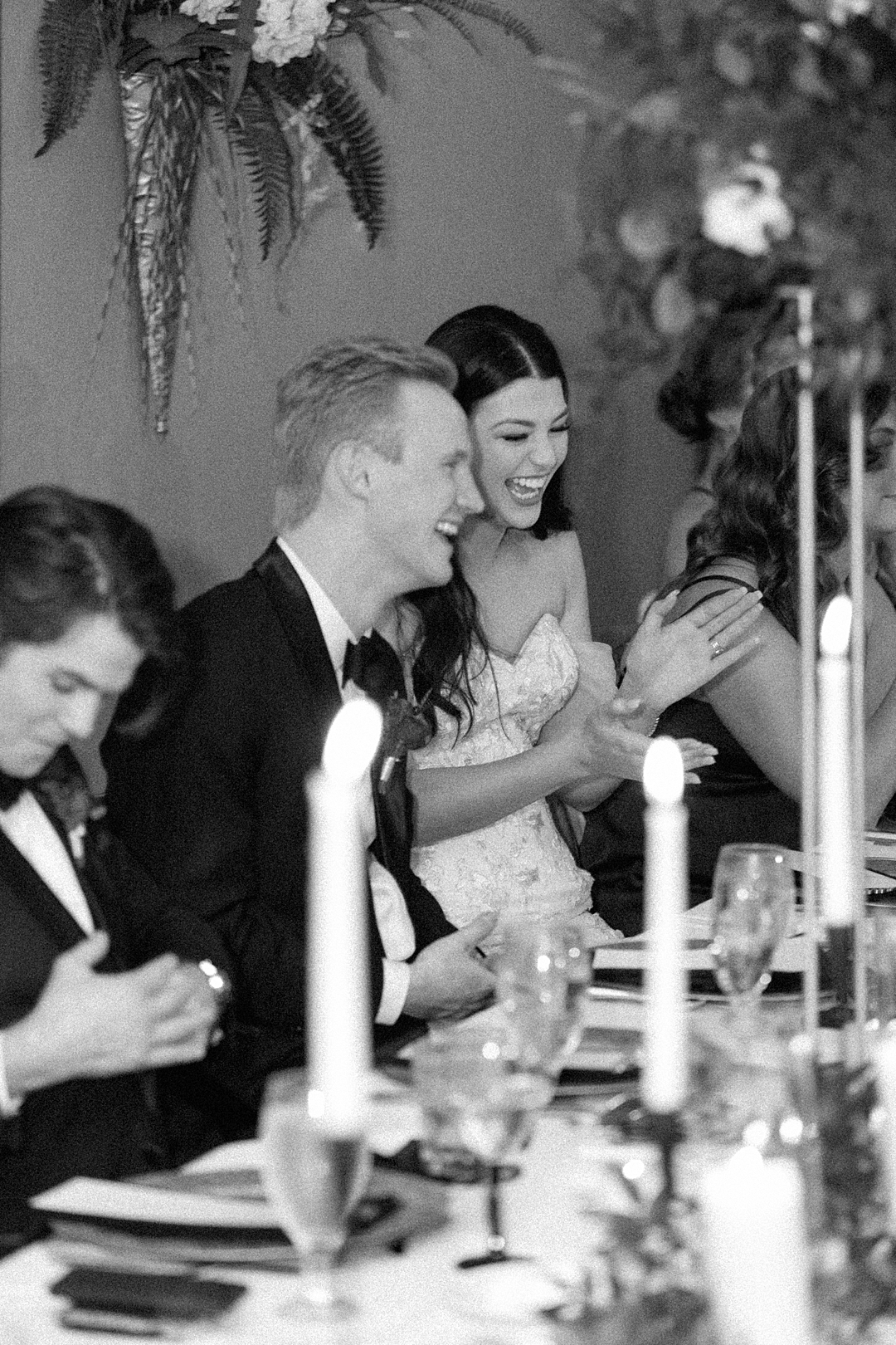 Bride and groom laughing during reception dinner