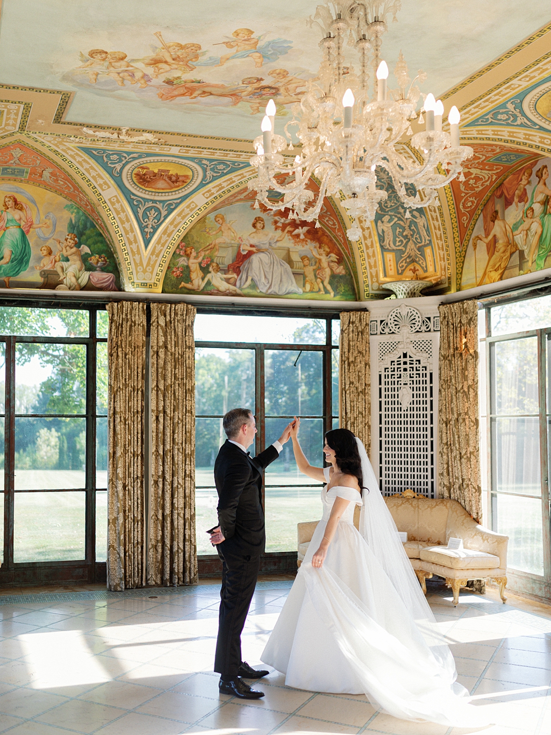 Couple in a historic room with chandelier and painted ceiling