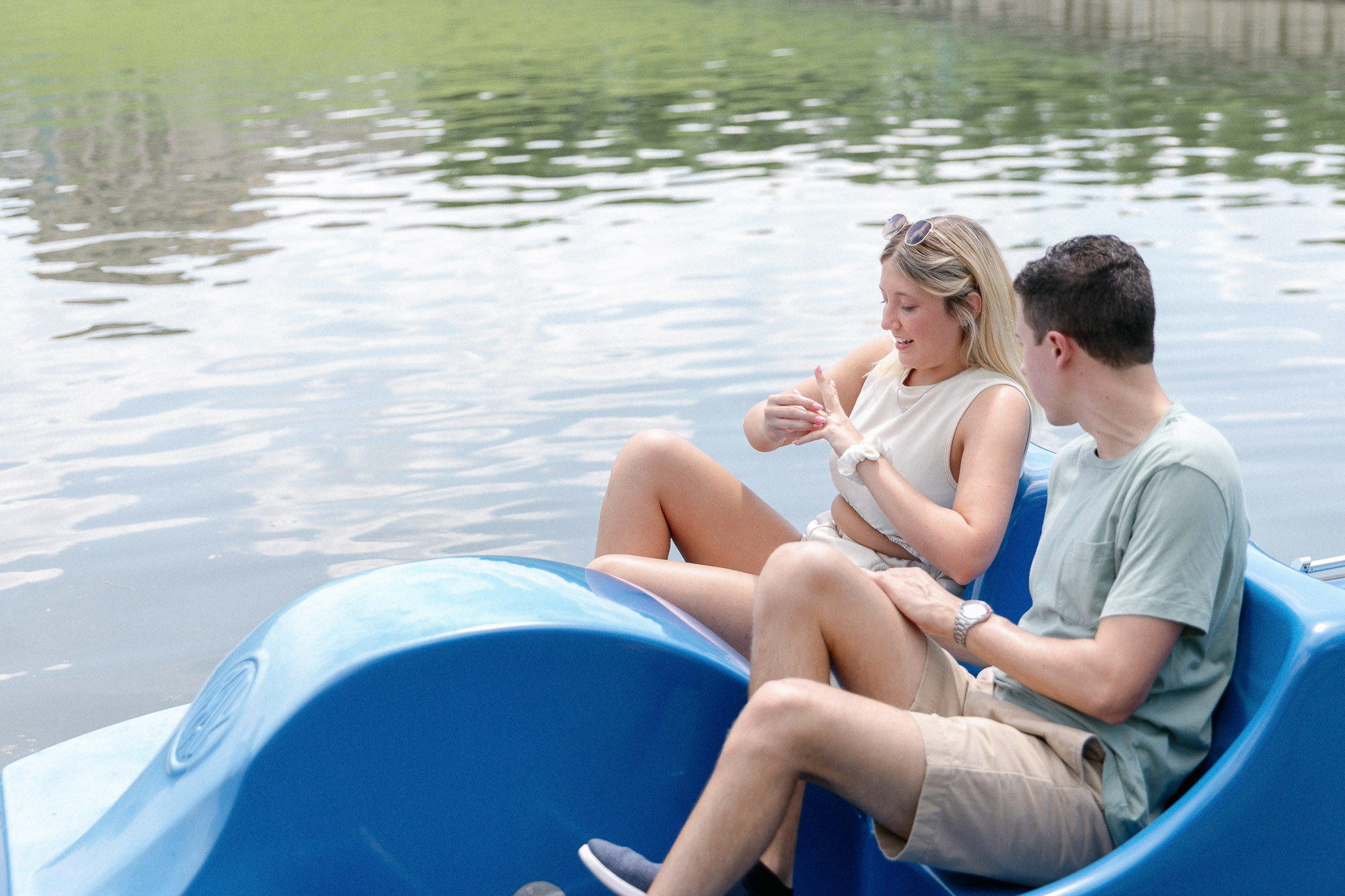 Bride-to-be showing off her ring while sitting on a paddle boat in Forest Park