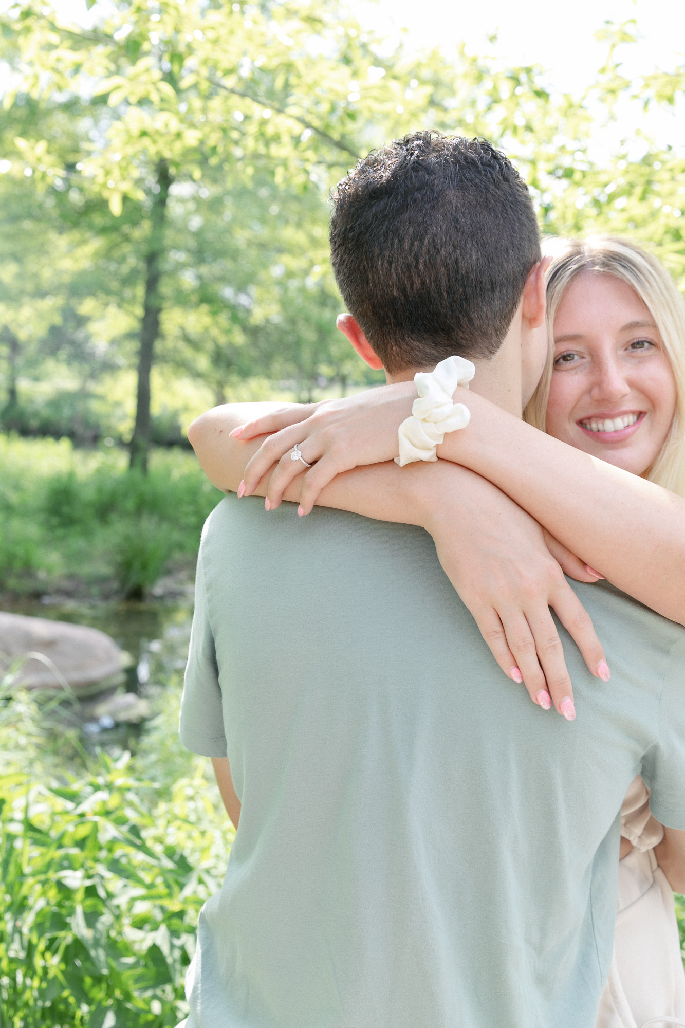 Close portrait of bride-to-be hugging her fiance after a Forest Park proposal