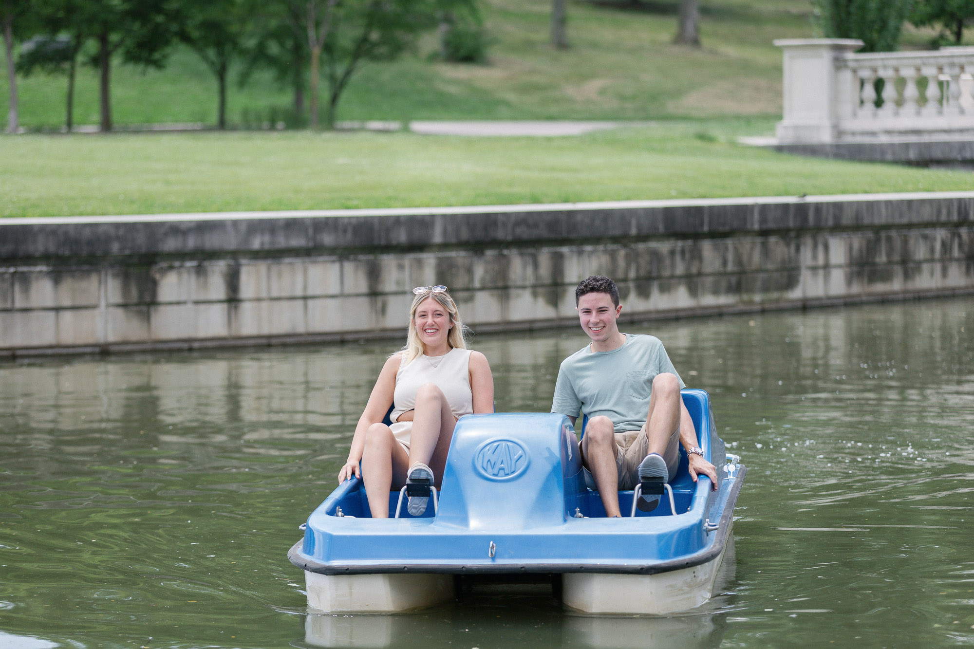 Couple sitting together on a paddle boat in Forest Park after the proposal