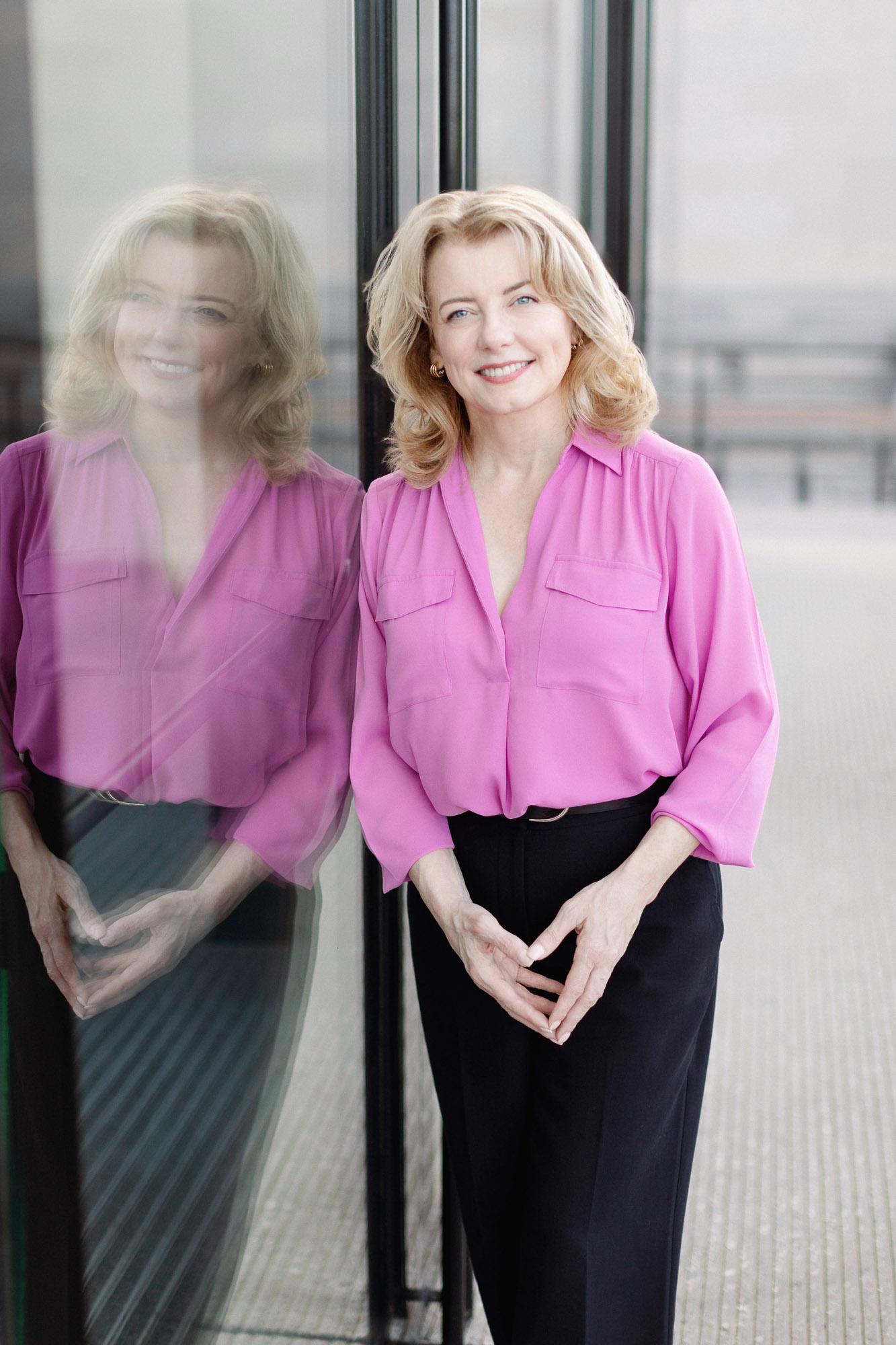 Professional branding style headshot of a woman in a pink blouse in St. Louis