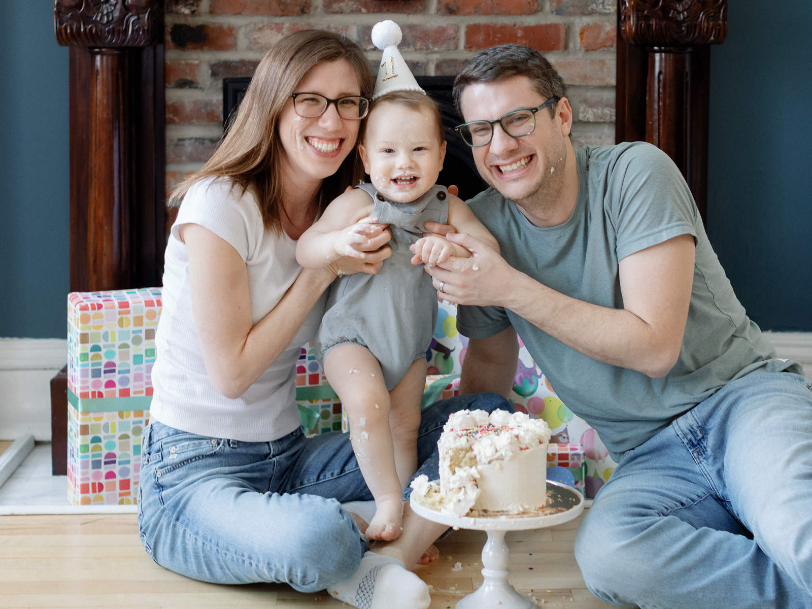 Baby with parents during a cake smash photography session in St Louis
