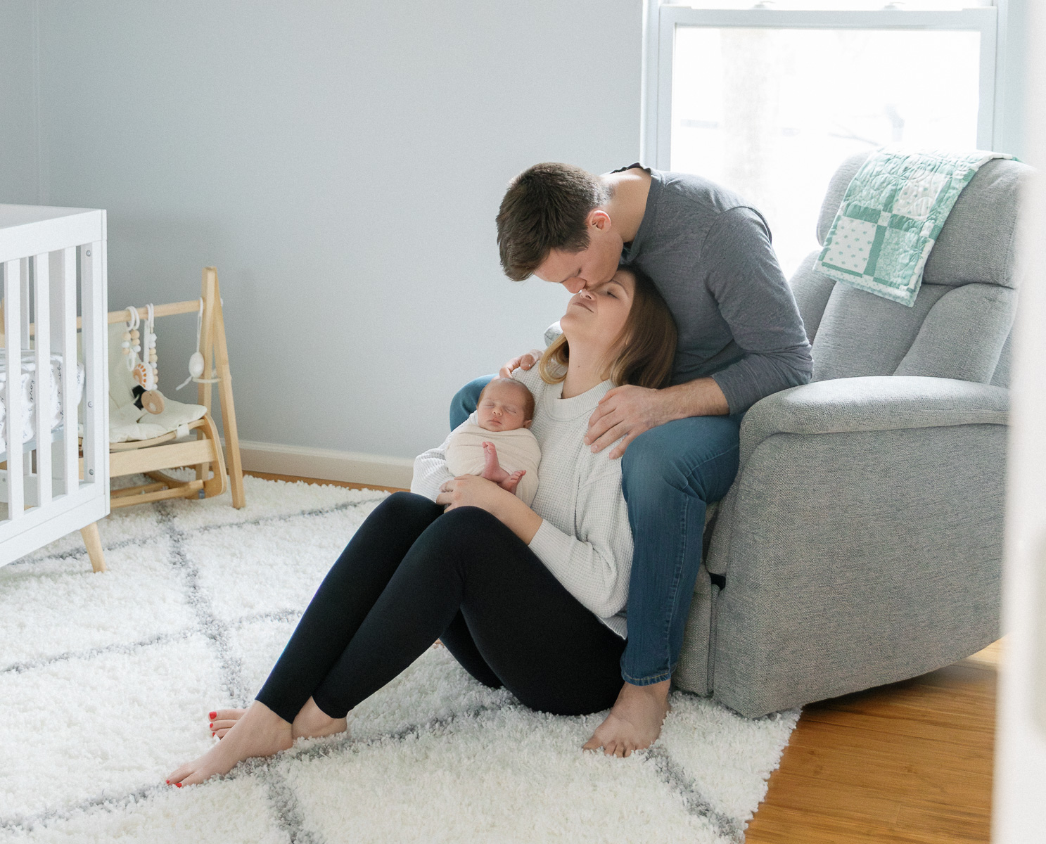 Parents holding their newborn during an in-home newborn photography session in St Louis