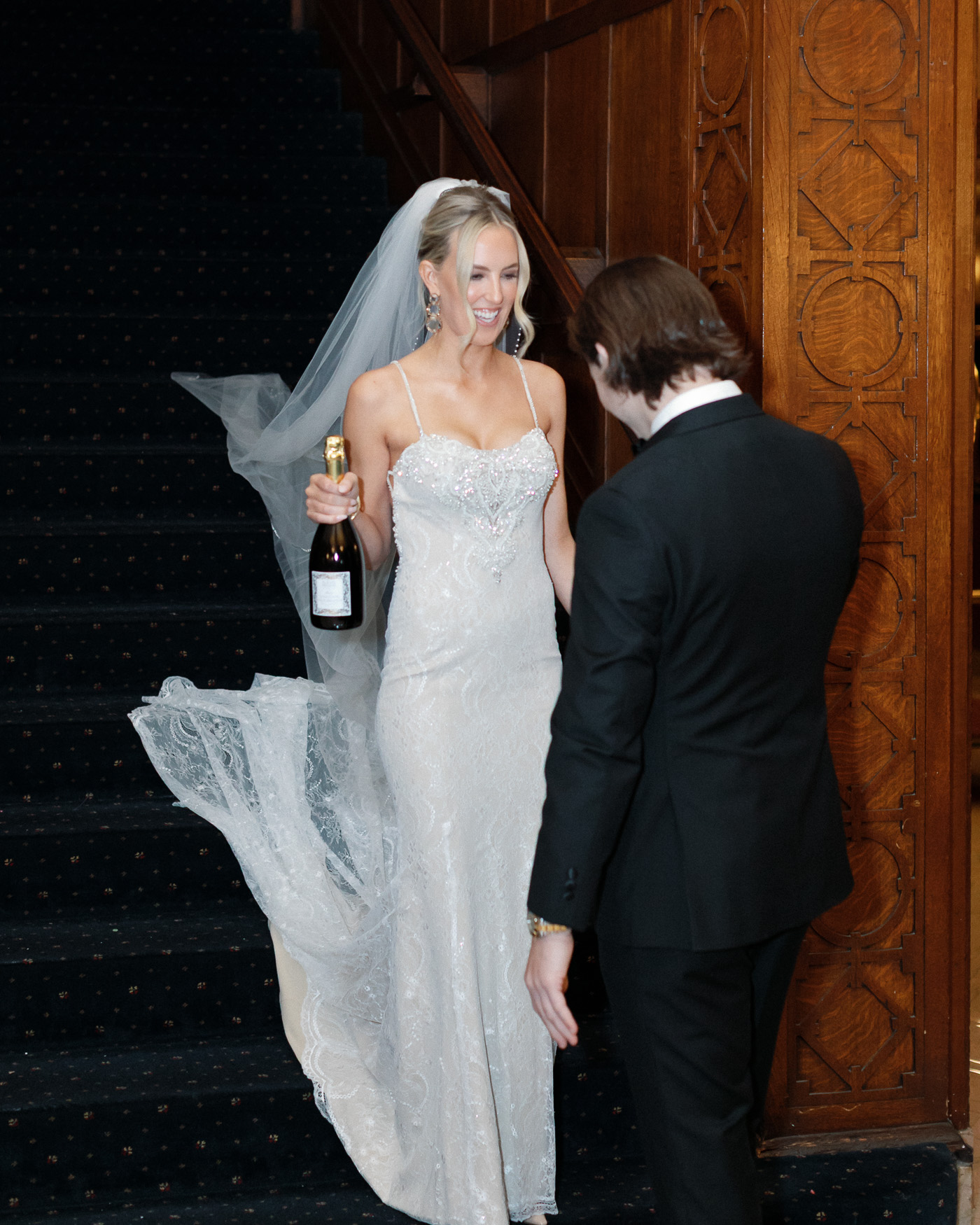Bride and groom during first look with champagne bottle at the Missouri Athletic Club