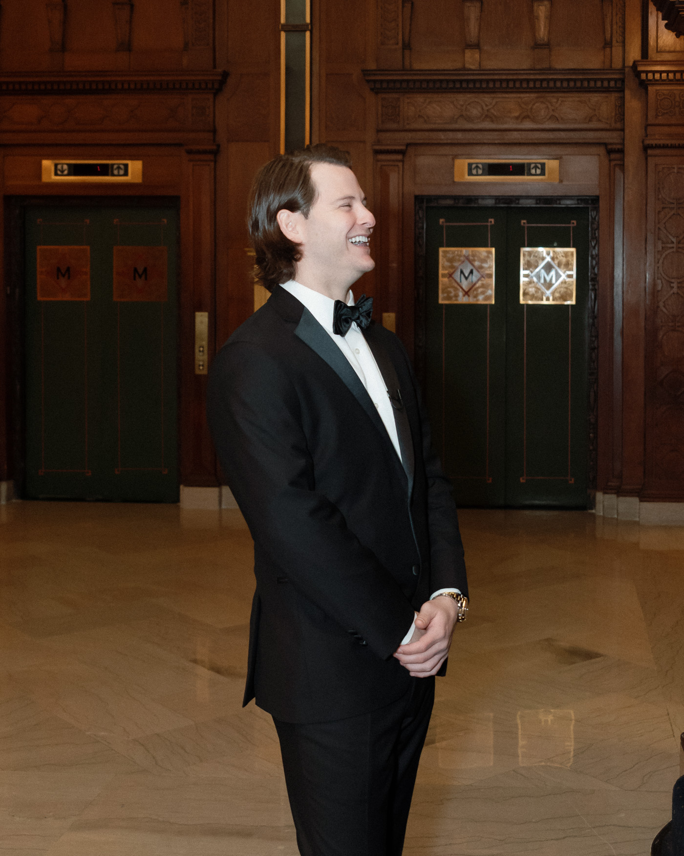 Bride approaching the groom with a champagne bottle during a first look at the Missouri Athletic Club