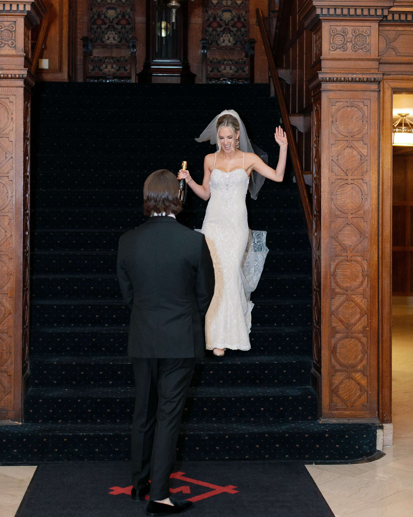 Bride holding a champagne bottle before first look wedding photos in St. Louis