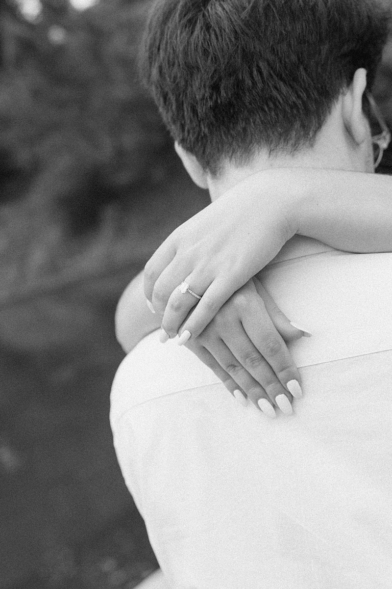 Black and white close up of Elise’s hand on Hayden’s shoulder
