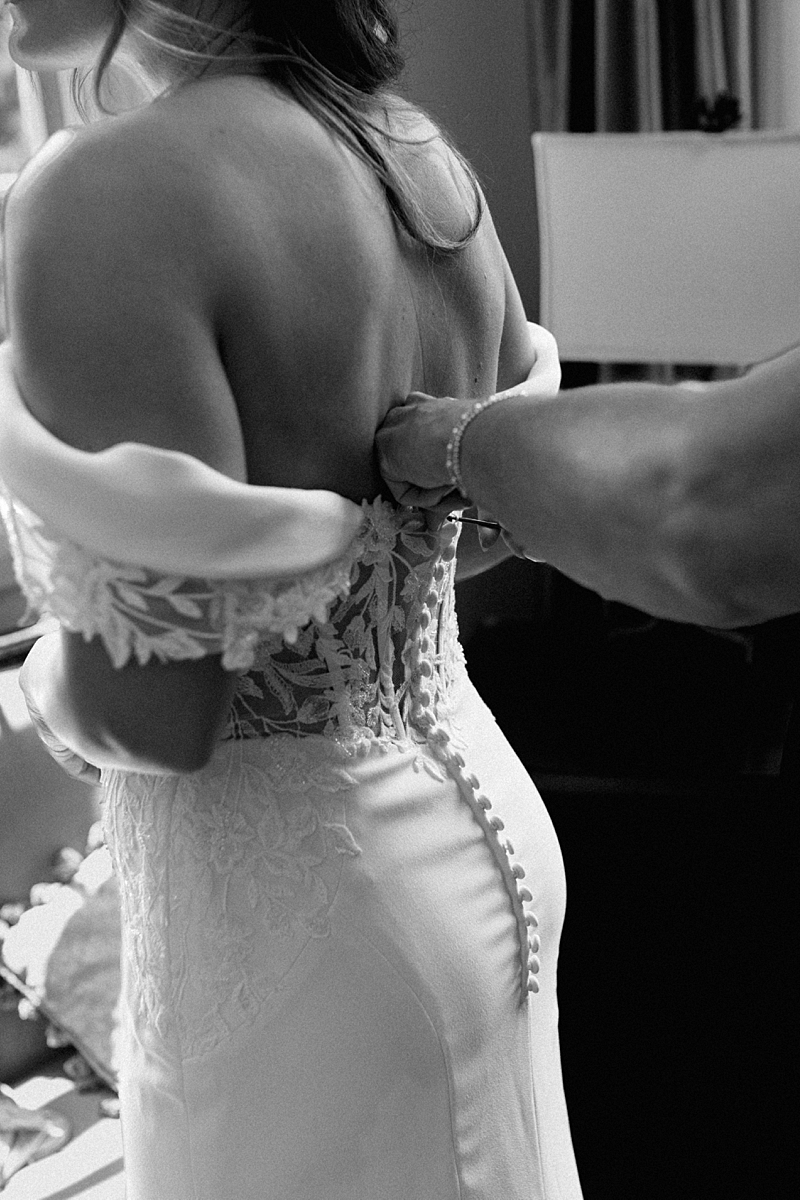 Haile’s mother fastening the back of her wedding gown