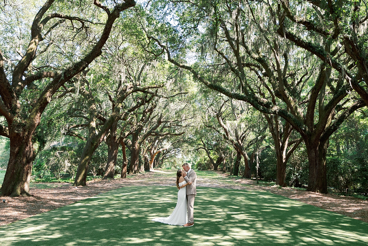 Haile and Clayton beneath the live oak trees during their Legare Waring House wedding in Charleston