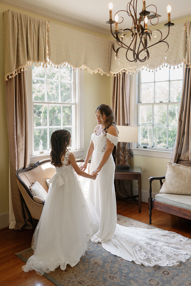 Haile holding hands with her daughter while getting ready at Legare Waring House