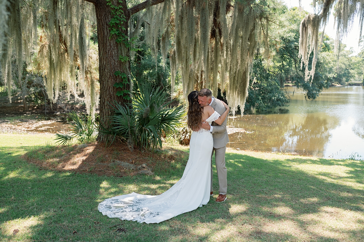 Haile and Clayton embracing beside the lagoon at Legare Waring House
