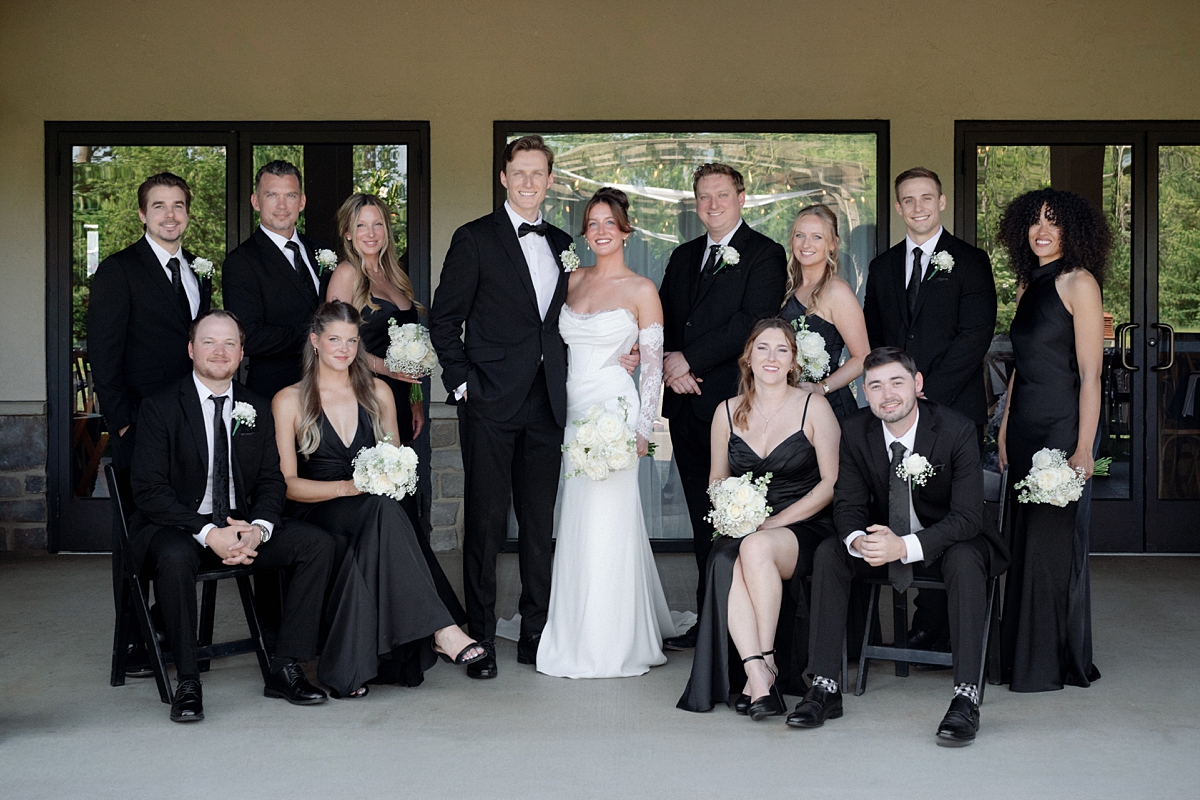 Outdoor wedding ceremony setup with black chairs and white florals