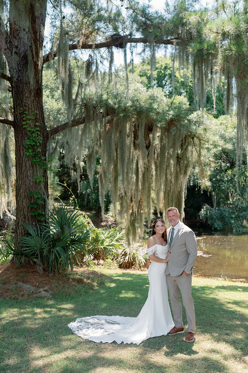 Haile and Clayton posing beneath Spanish moss beside the lagoon at Legare Waring House