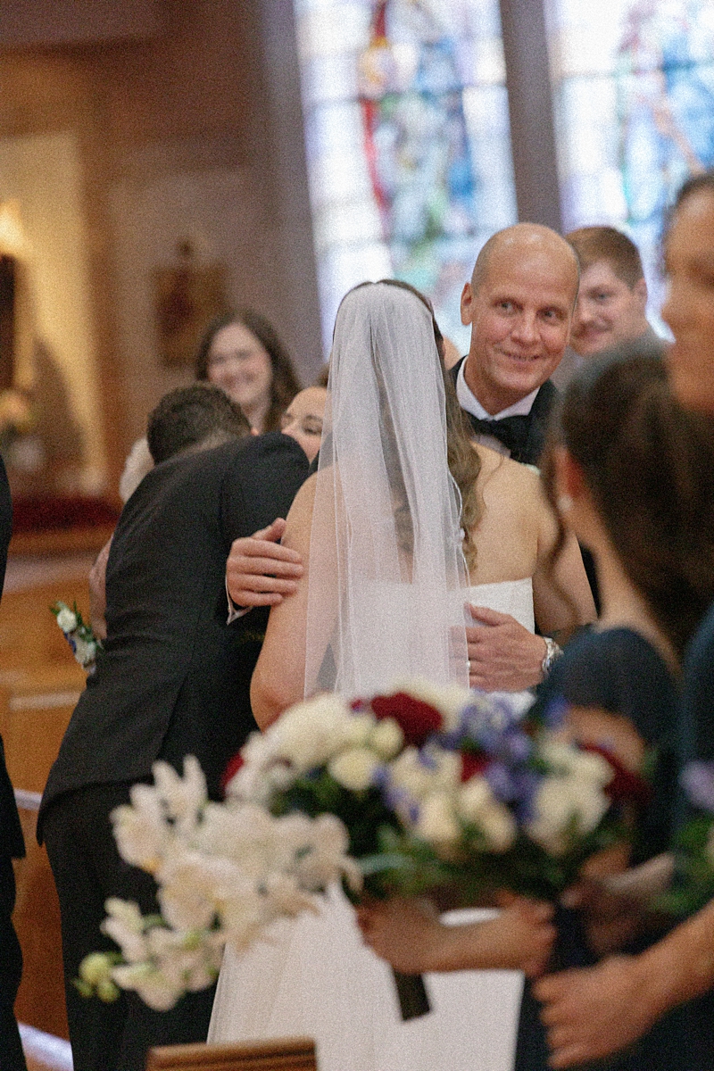 Jill hugging a family member inside the church after her ceremony