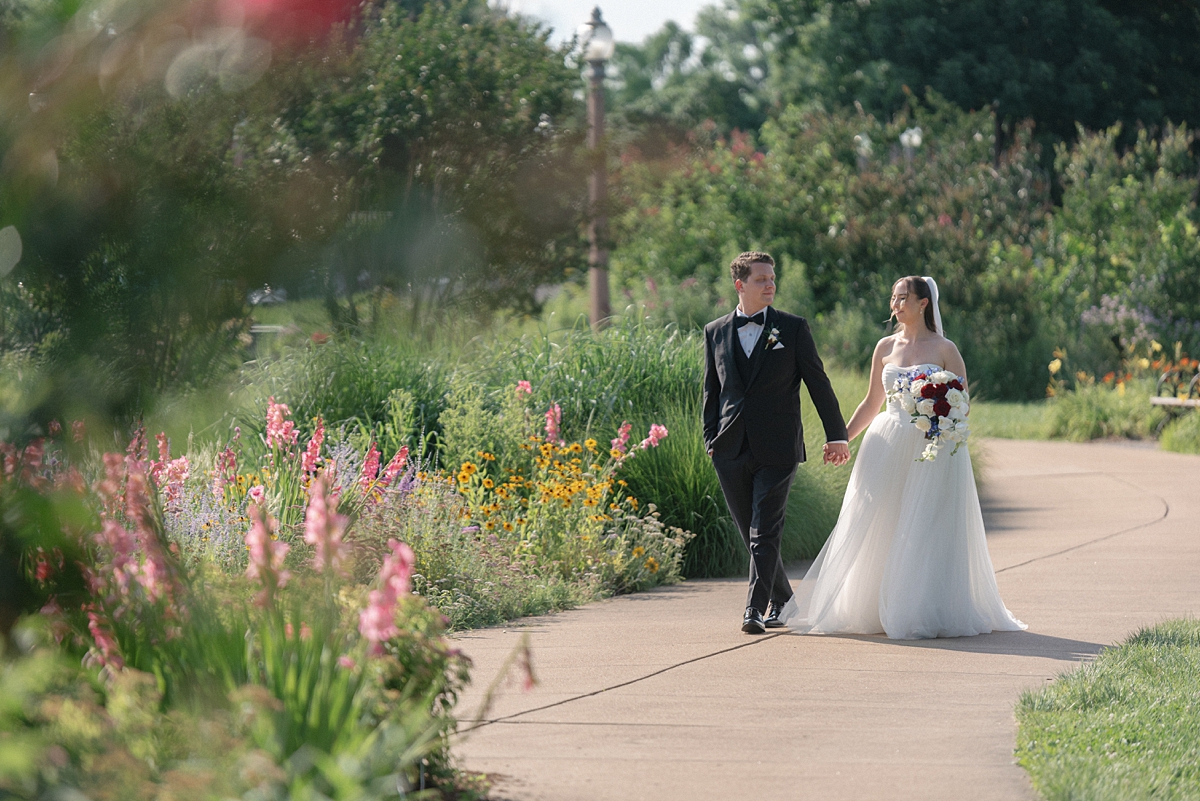 Jill and Dylan walking through flowers during their Forest Park wedding portraits