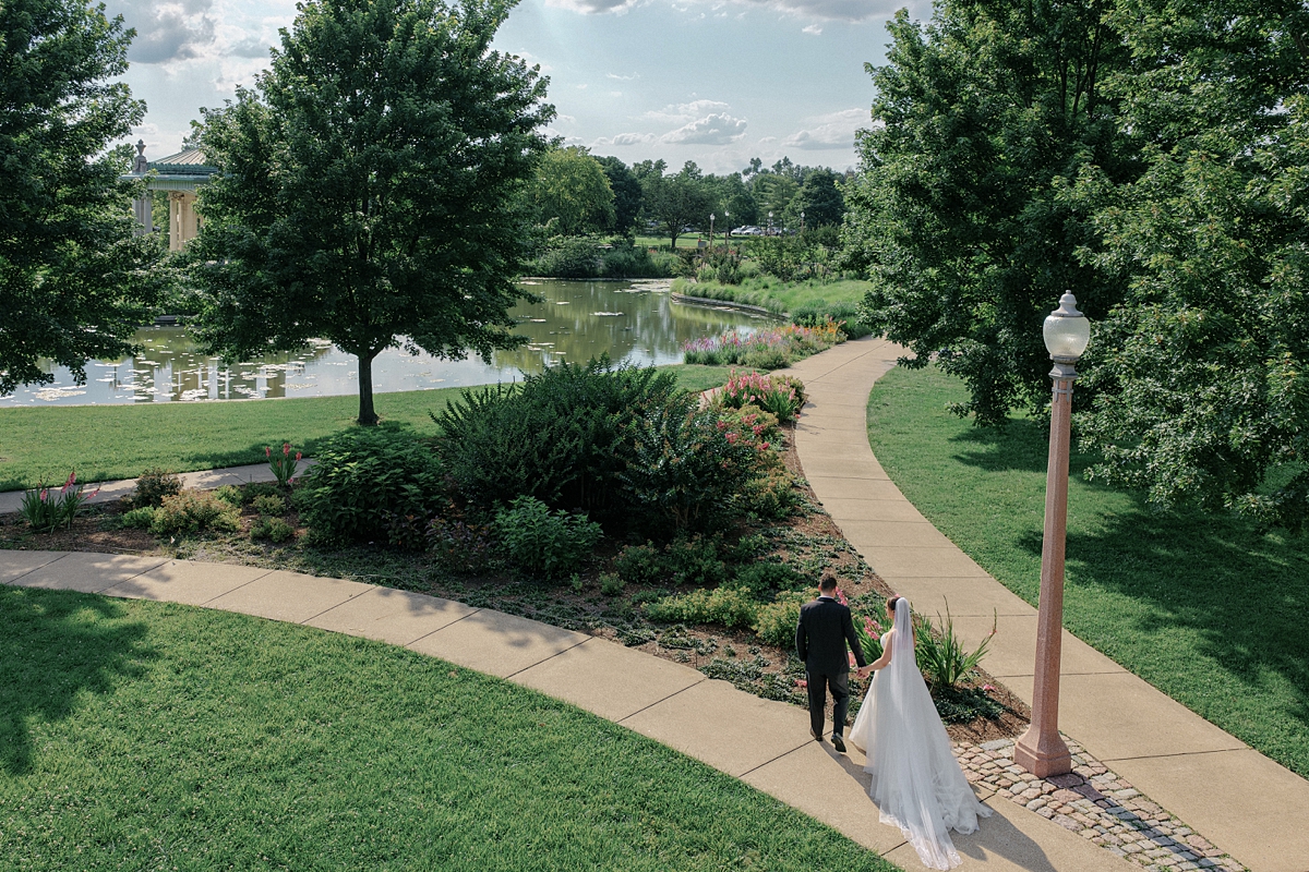 Aerial Forest Park wedding photo of Jill and Dylan walking through the park