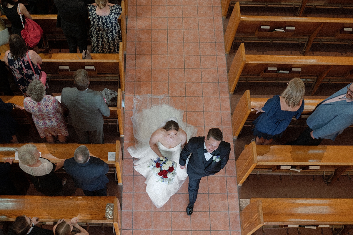 Overhead photograph of Jill and Dylan walking down the aisle after their ceremony