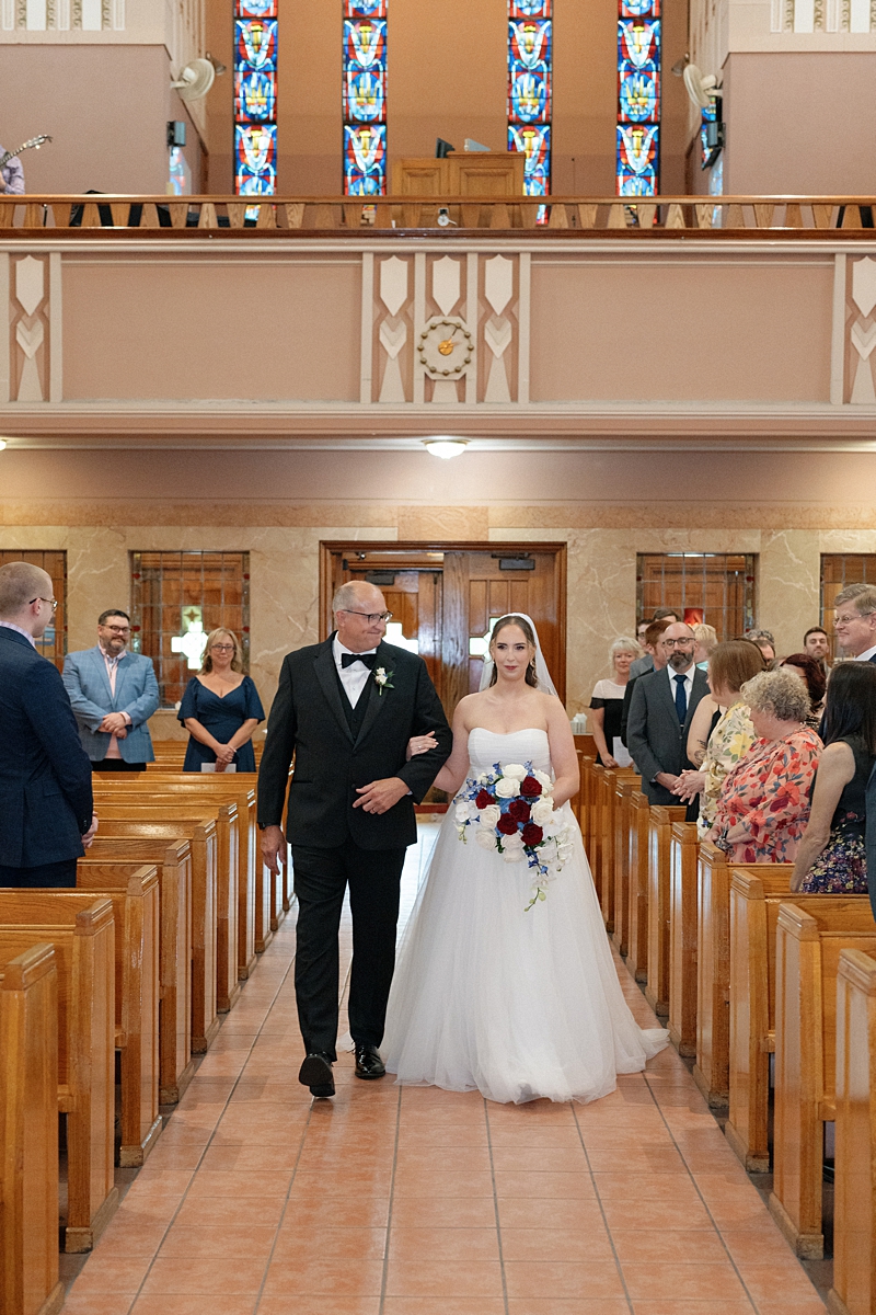 Jill walking down the aisle with her father during her St. Louis Catholic wedding