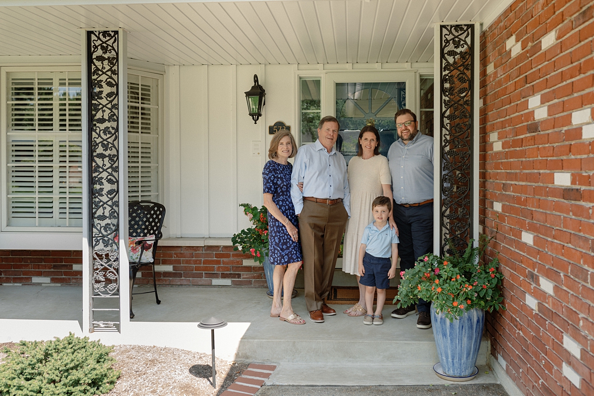 Extended family standing together on the front porch of a St. Louis home
