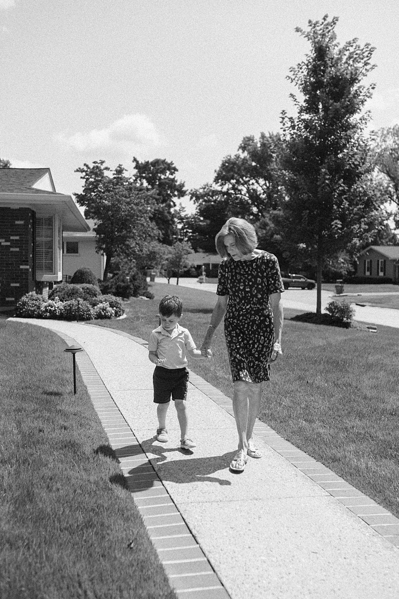 Black and white photograph of a grandmother walking with her grandson