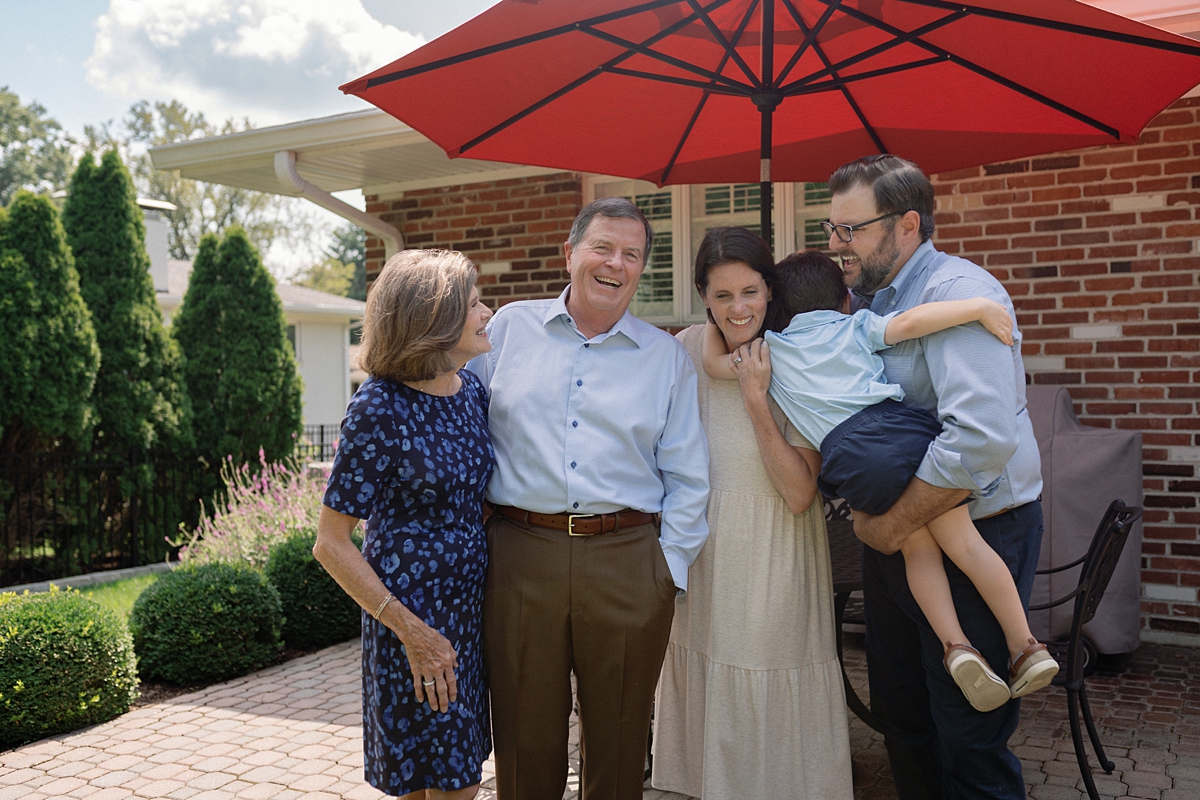 Family laughing together in the backyard during a St. Louis photo session