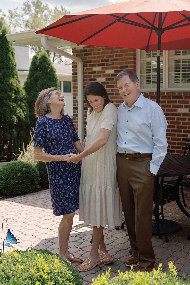 Parents and their adult daughter sharing a moment during an extended family session