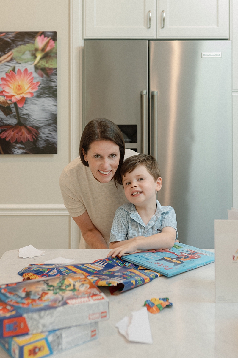 Mother holding her son after opening birthday presents at home
