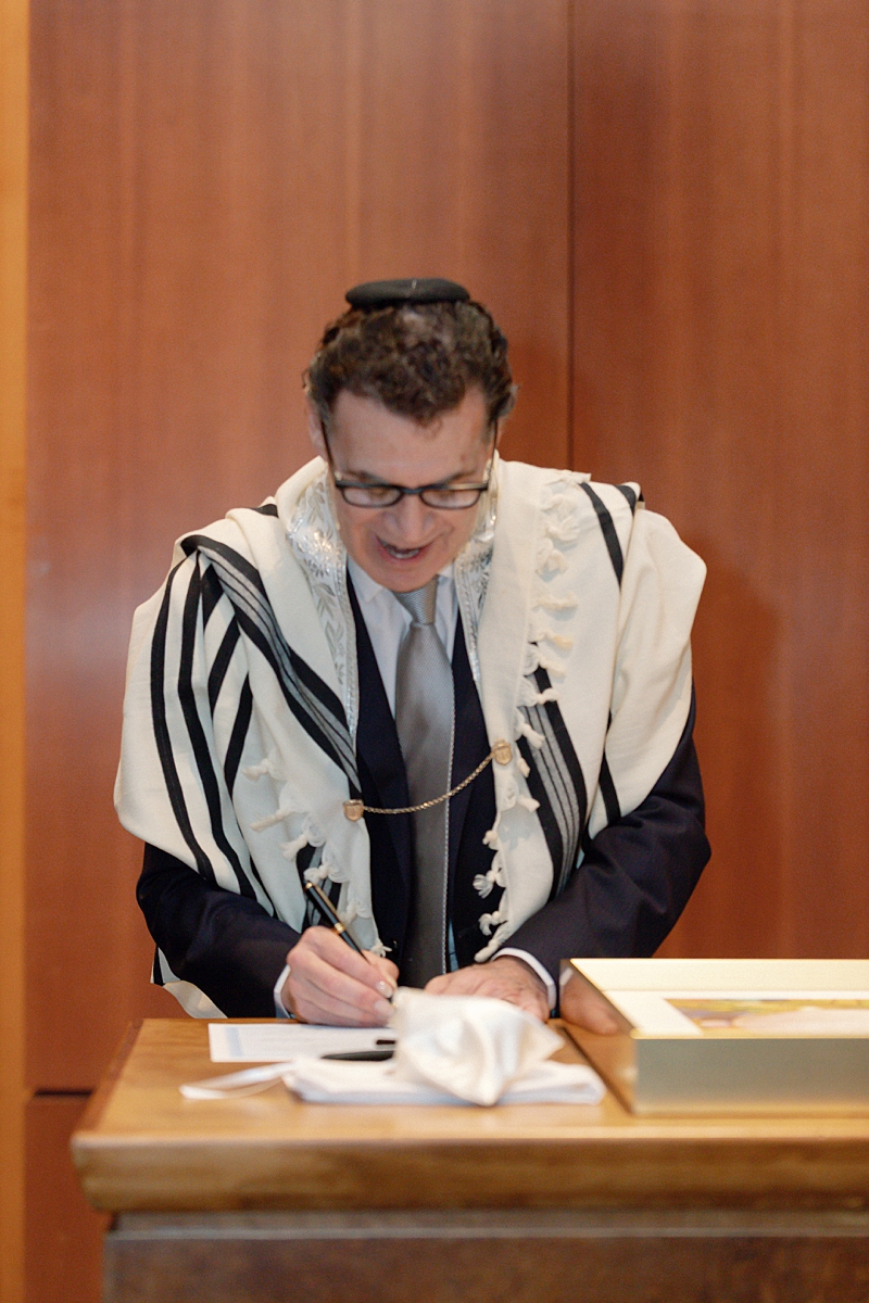 The officiant signing a document before Allie and Nathan's ceremony